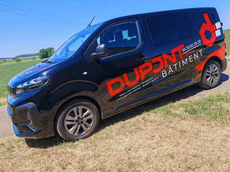 Flanc du Peugeot Expert noir marqué aux couleurs de Dupont Bâtiment